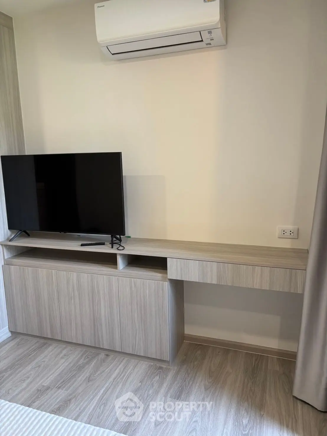 Modern living room with sleek TV stand and air conditioning unit, perfect for comfortable living.