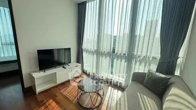 Bright living room with modern furniture and large windows in a stylish apartment.