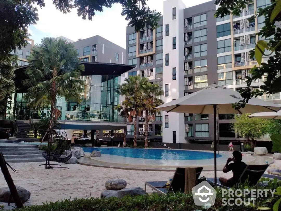 Luxurious pool area with tropical palm trees in a modern residential complex, offering a serene oasis for relaxation and socializing.