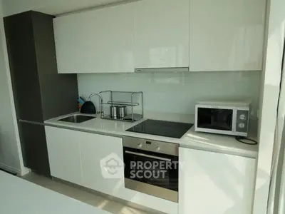 Modern kitchen with sleek white cabinets and built-in appliances