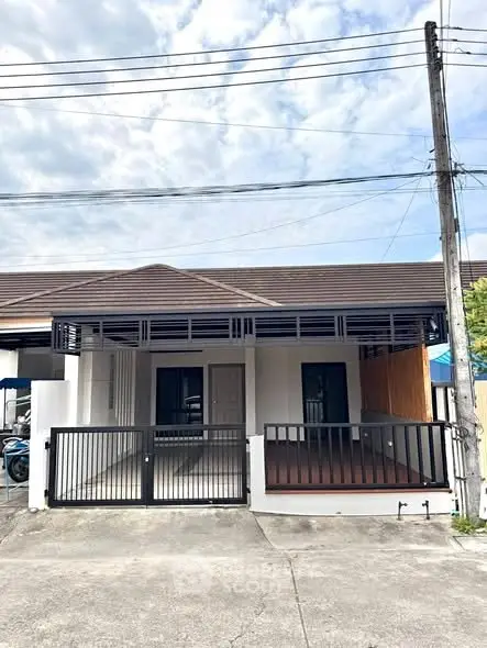 Charming single-story home with modern facade and gated driveway in a serene neighborhood.