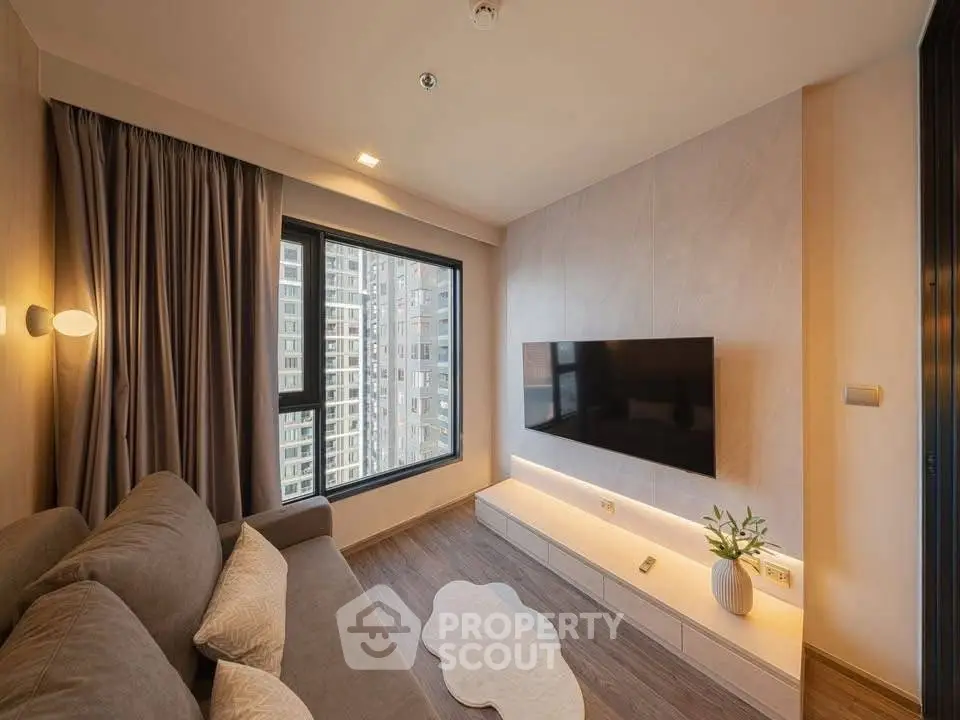 Modern living room with large window and mounted TV, featuring elegant decor and city view.