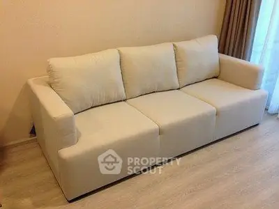 Elegant beige sofa in a cozy living room setting with wooden flooring.