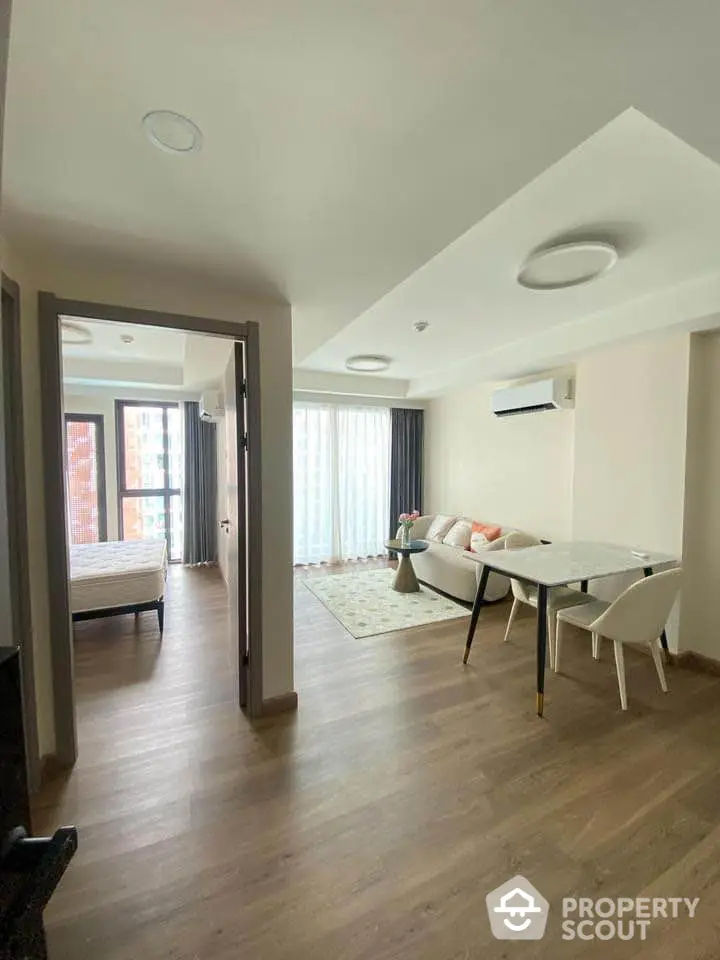 Modern open-plan living room with stylish furniture and large windows in a contemporary apartment.