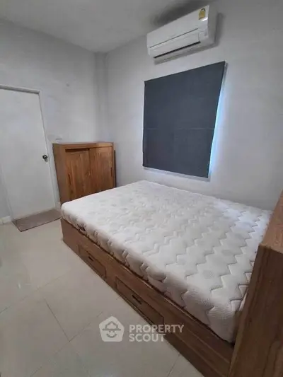 Cozy bedroom with modern air conditioning and wooden furniture, perfect for restful nights.