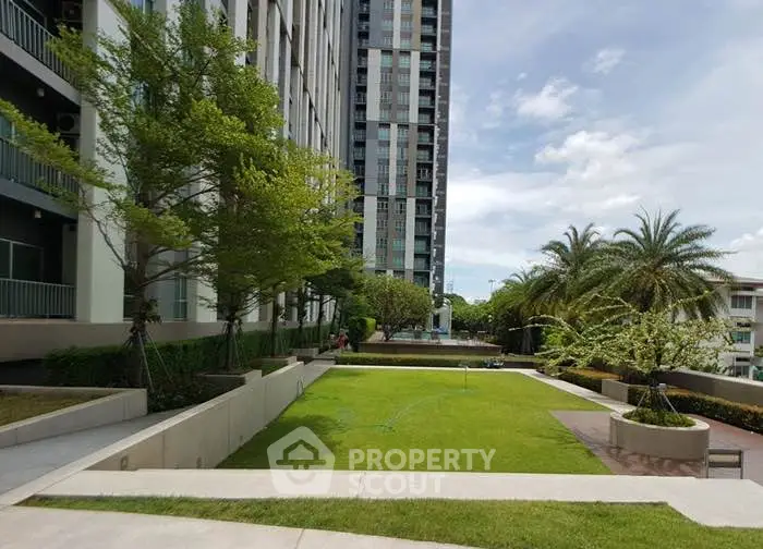 Modern residential building with lush garden and palm trees, perfect for urban living.