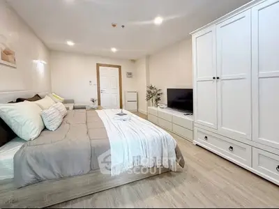 Spacious modern bedroom with stylish decor and ample storage in a cozy apartment.