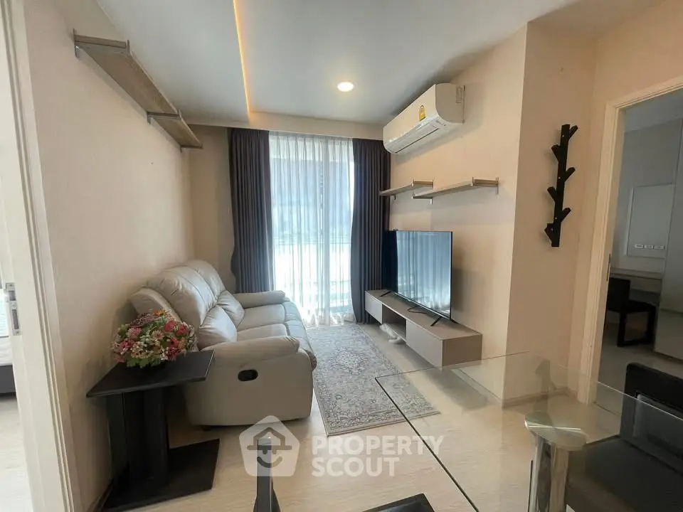 Modern living room with sleek furniture and large window, perfect for relaxation and entertainment.