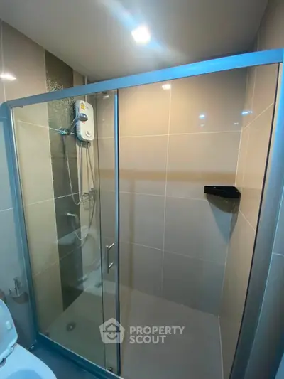 Modern bathroom with glass shower enclosure and sleek tile design
