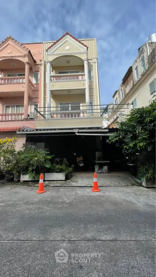 Charming multi-story residential building with classic architecture and lush greenery.
