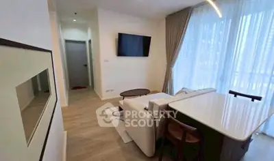 Modern living room with stylish furniture and large window offering natural light.