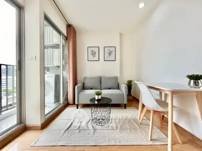 Modern living room with balcony view, stylish decor, and natural light.