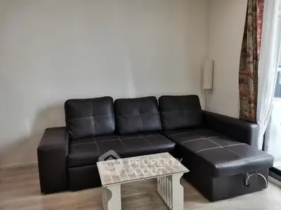 Modern living room with sleek black leather sectional sofa and stylish coffee table.