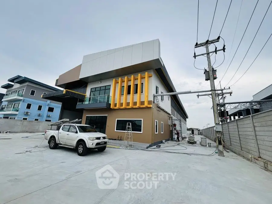 Modern commercial building with unique architectural design and spacious parking area.