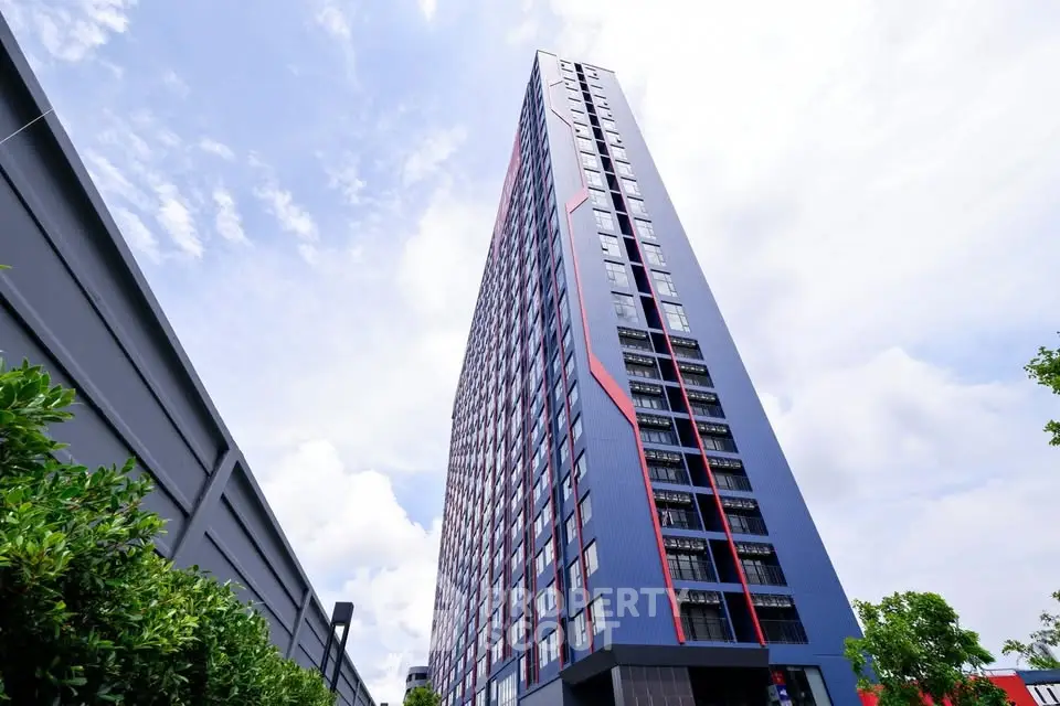 Modern high-rise building with sleek design and vibrant exterior colors, showcasing urban living at its finest.