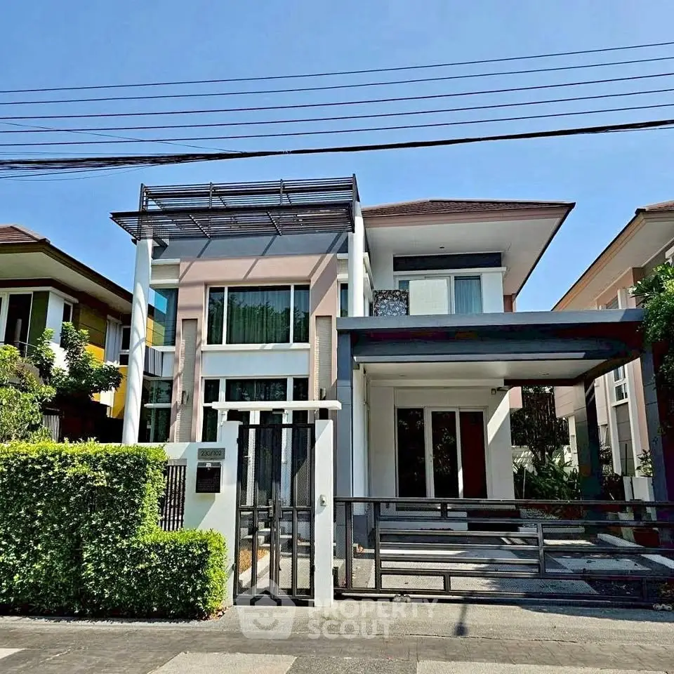 Modern two-story house with sleek design and spacious driveway in a suburban neighborhood.