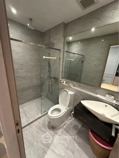 Modern bathroom with glass shower and sleek fixtures in a contemporary home.