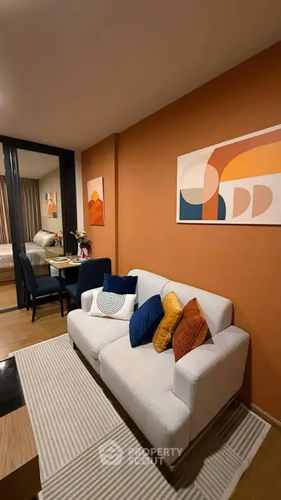 Stylish living room with modern decor and vibrant accent wall in a cozy apartment.