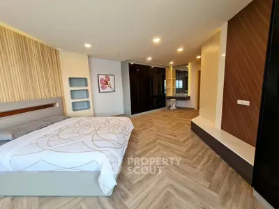 Spacious modern bedroom with elegant decor and herringbone flooring