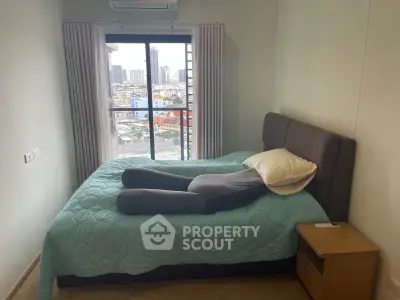 Cozy bedroom with city view, featuring a comfortable bed and modern decor, perfect for urban living.
