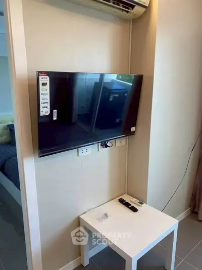 Modern living room with wall-mounted TV and sleek white table