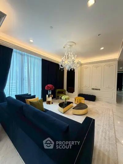Luxurious living room with elegant chandelier and plush seating in a sophisticated interior design.