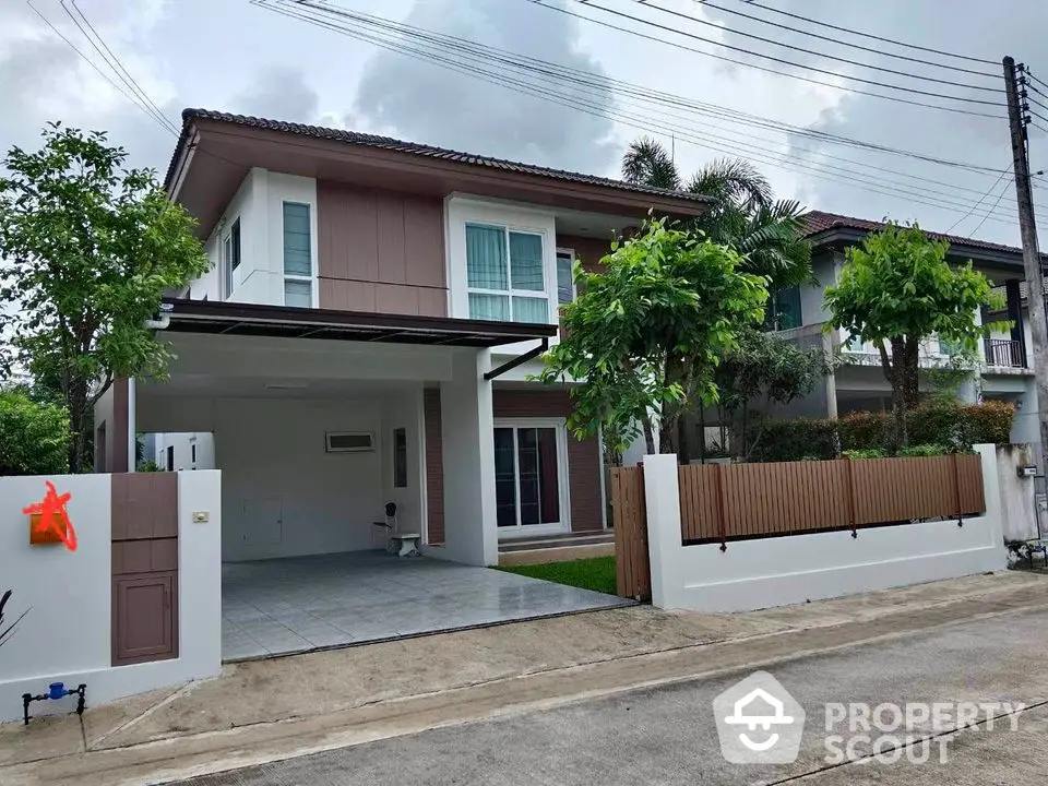 Modern two-story house with spacious driveway and lush greenery in a serene neighborhood.