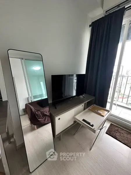 Modern living room with TV, mirror, and balcony view