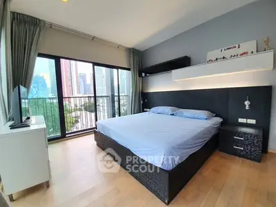 Spacious bedroom with large windows and city view, featuring modern decor and ample natural light.