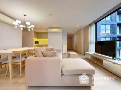 Spacious modern living room with open kitchen and large windows in luxury apartment