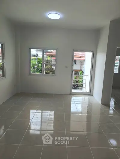 Bright and spacious living room with large windows and balcony access, perfect for natural light lovers.