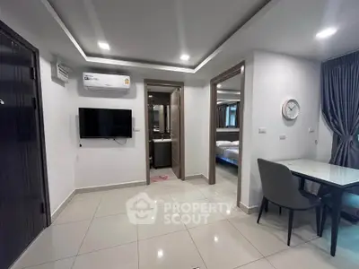 Modern apartment interior with sleek design, featuring a wall-mounted TV, air conditioning, and stylish dining area.