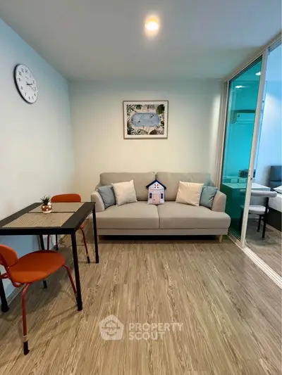 Modern living room with cozy sofa, dining table, and stylish decor in a compact apartment.