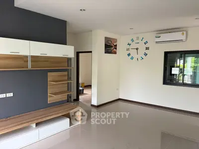 Modern living room with sleek storage and wall clock, featuring air conditioning and stylish decor.