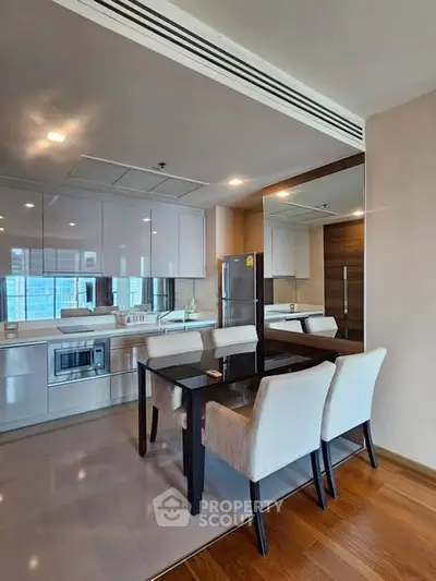 Modern kitchen with sleek cabinetry and dining area in a stylish apartment.