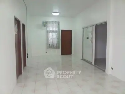 Spacious empty room with tiled floor and sliding glass doors
