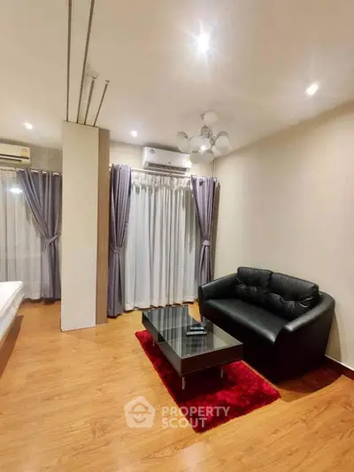 Modern living room with sleek black sofa and glass coffee table on red rug