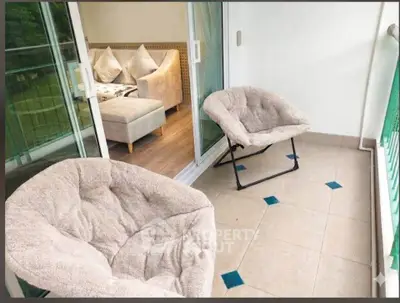Charming balcony with cozy seating and view into stylish living room