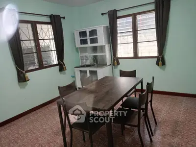 Cozy dining area with modern table and chairs, featuring large windows and ample natural light.