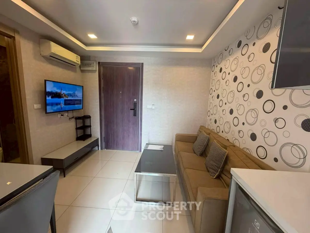 Modern living room with stylish decor and wall-mounted TV in a cozy apartment.