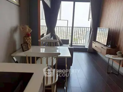 Modern living room with balcony view, sleek furniture, and natural light.