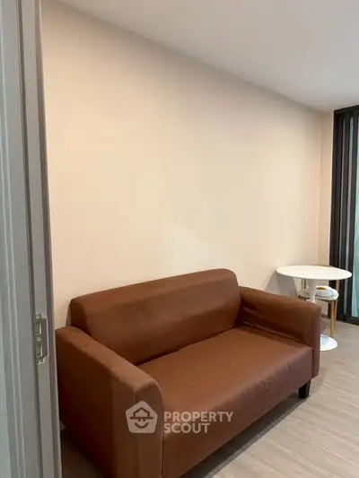 Cozy living room with brown sofa and small dining table, perfect for compact spaces.