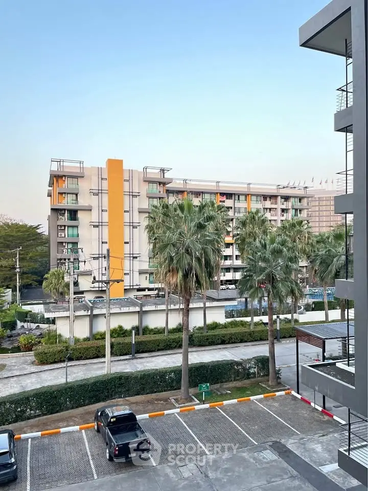Modern apartment building with palm trees and parking area view