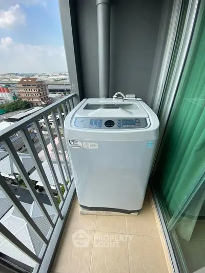 Compact balcony with washing machine and city view