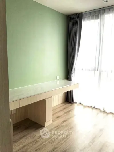 Bright study room with large window and modern desk in a stylish apartment.
