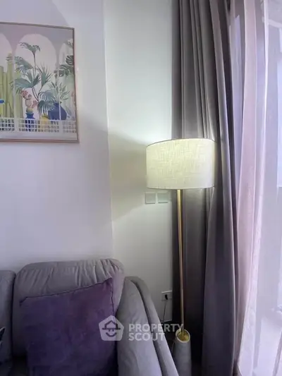 Cozy living room corner with elegant floor lamp and plush sofa, perfect for relaxation.