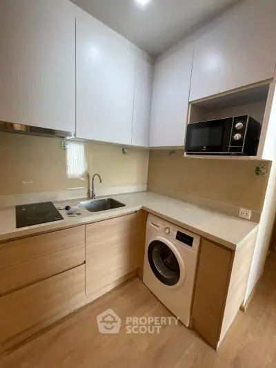 Modern kitchen with sleek cabinetry, built-in appliances, and wood flooring in a compact layout.