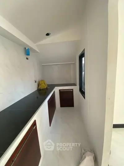 Modern kitchen with sleek countertops and minimalist design, featuring a closed layout and ample natural light.