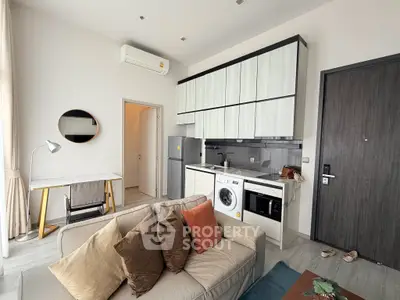 Modern living room with integrated kitchen, featuring a washing machine and stylish decor.