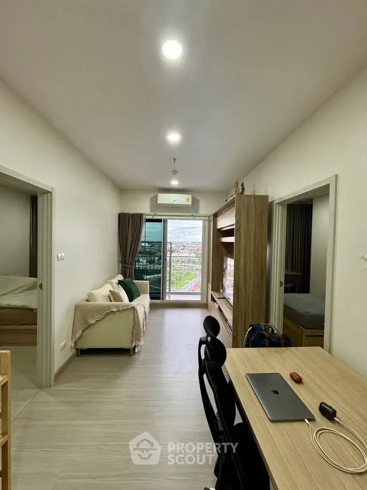Modern apartment interior with open layout, featuring a cozy living area and a scenic view from the window.